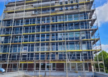 Stavba lešení na fasáde polikliniky v Brně, které je potřebné na výstavbu kontrolovaného pásma, které je nevyhnuté k likvidaci azbestu.